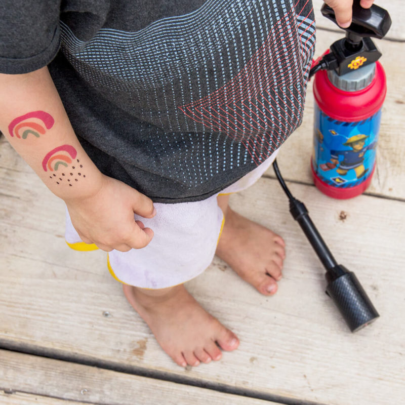 Kleiner und Mini Regenbogen als Klebetattoo auf dem Arm eines 3-jährigen Jungen