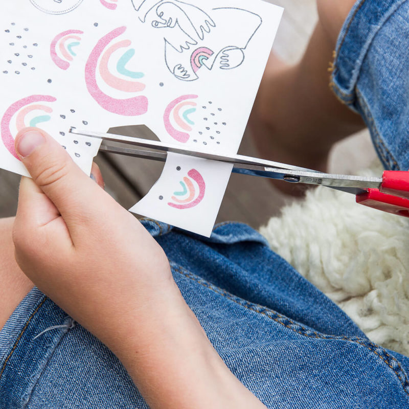 Regenbogen Tattoo Motive werden mit der Schere ausgeschnitten