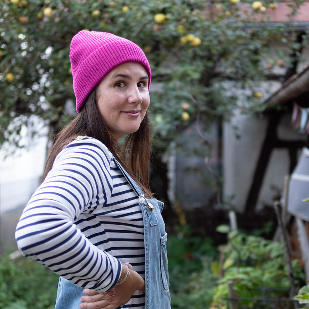 Sarah Gilgien trägt Fisherman Beanie Kleiner Regenbogen in der Farbe fuchsia